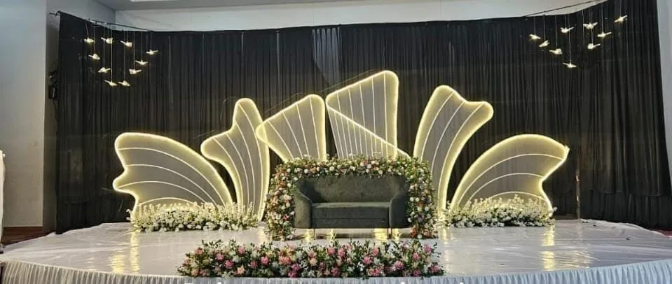 Stage with glowing shell-shaped panels against black drapes